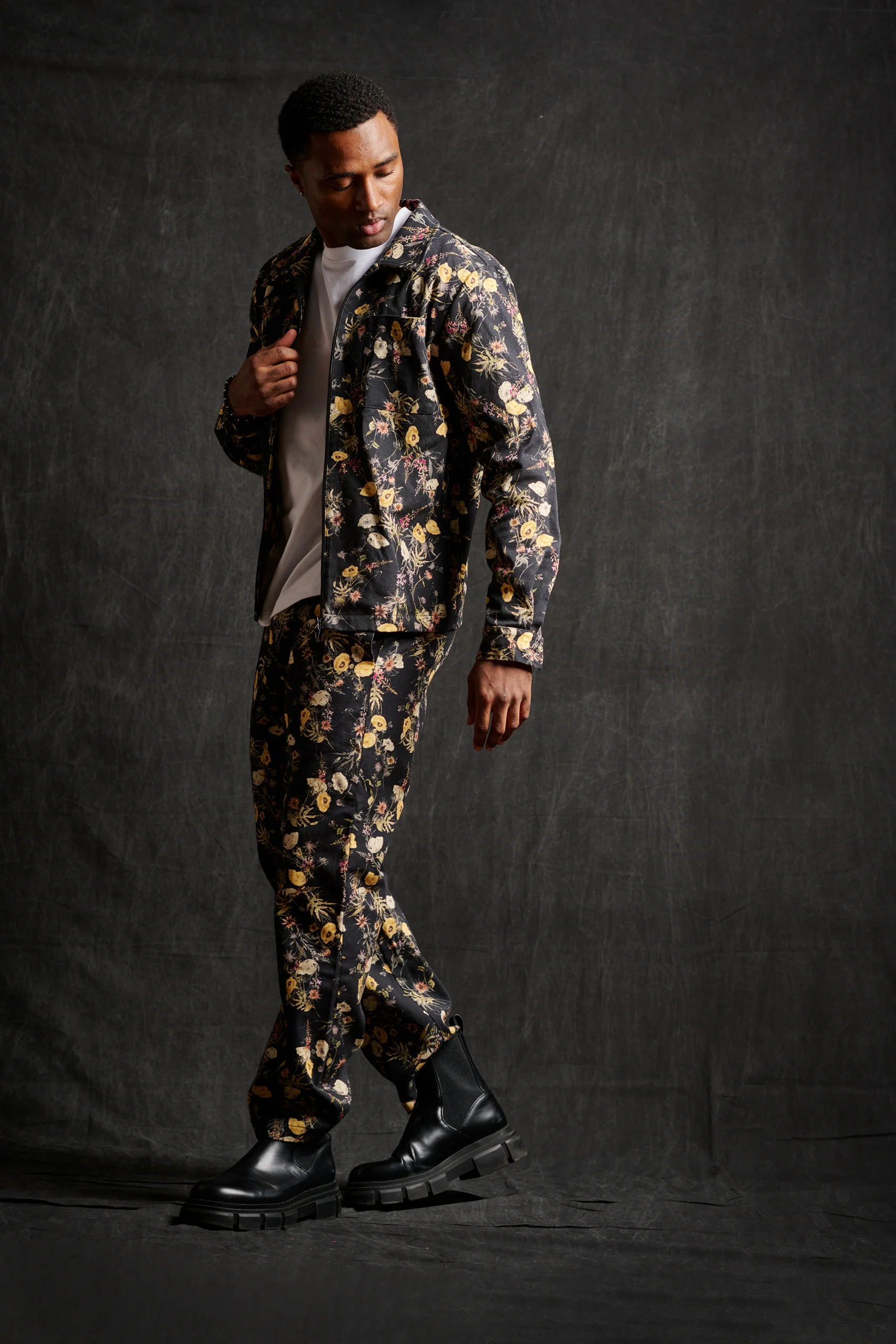 A model wearing a dark suit with a colorful floral pattern.
