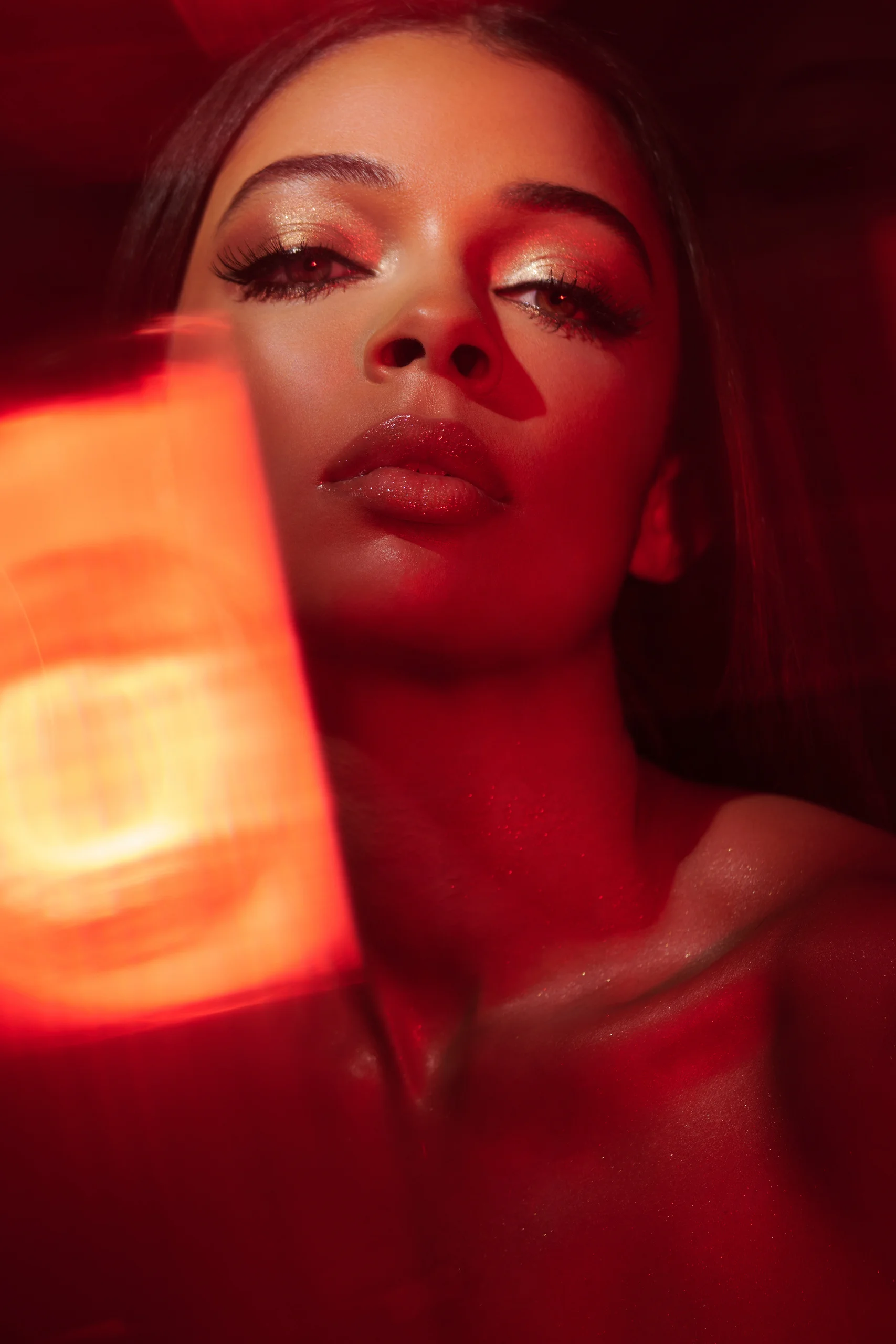 A beauty portrait through orange and red reflections.