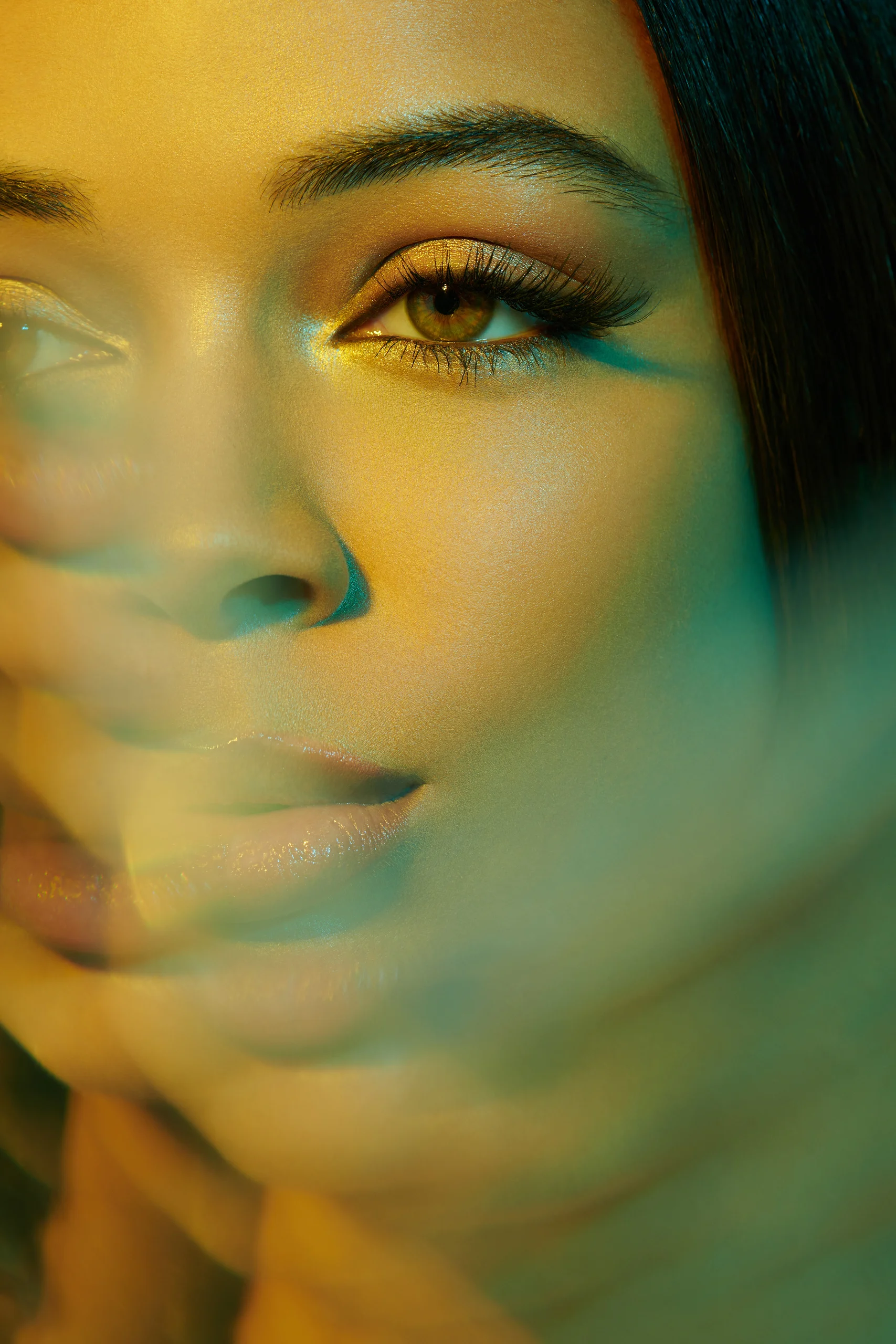 A beauty portrait through soft yellow and turquoise reflections.