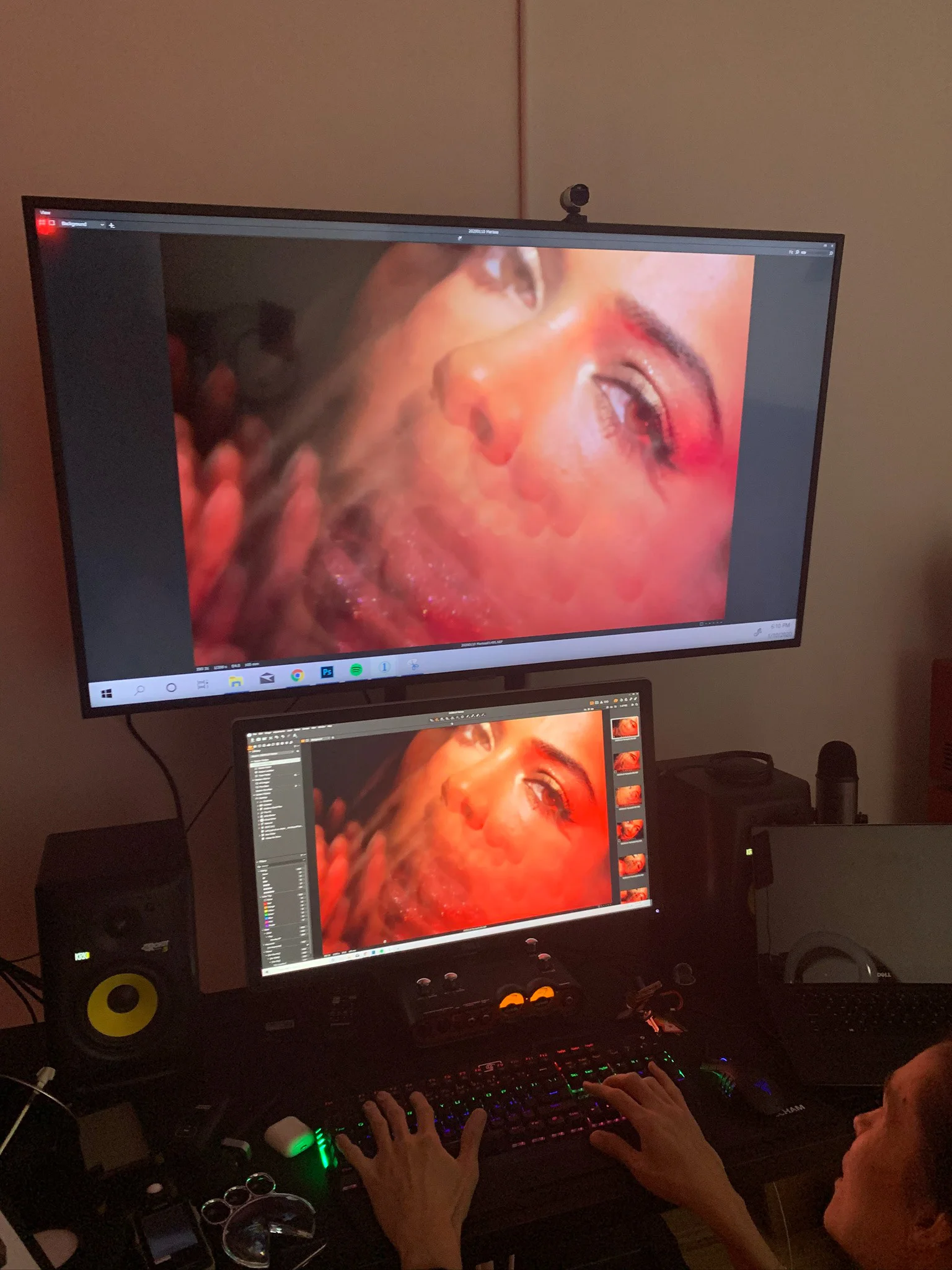 A retouching workstation showing a close beauty portrait on two displays.