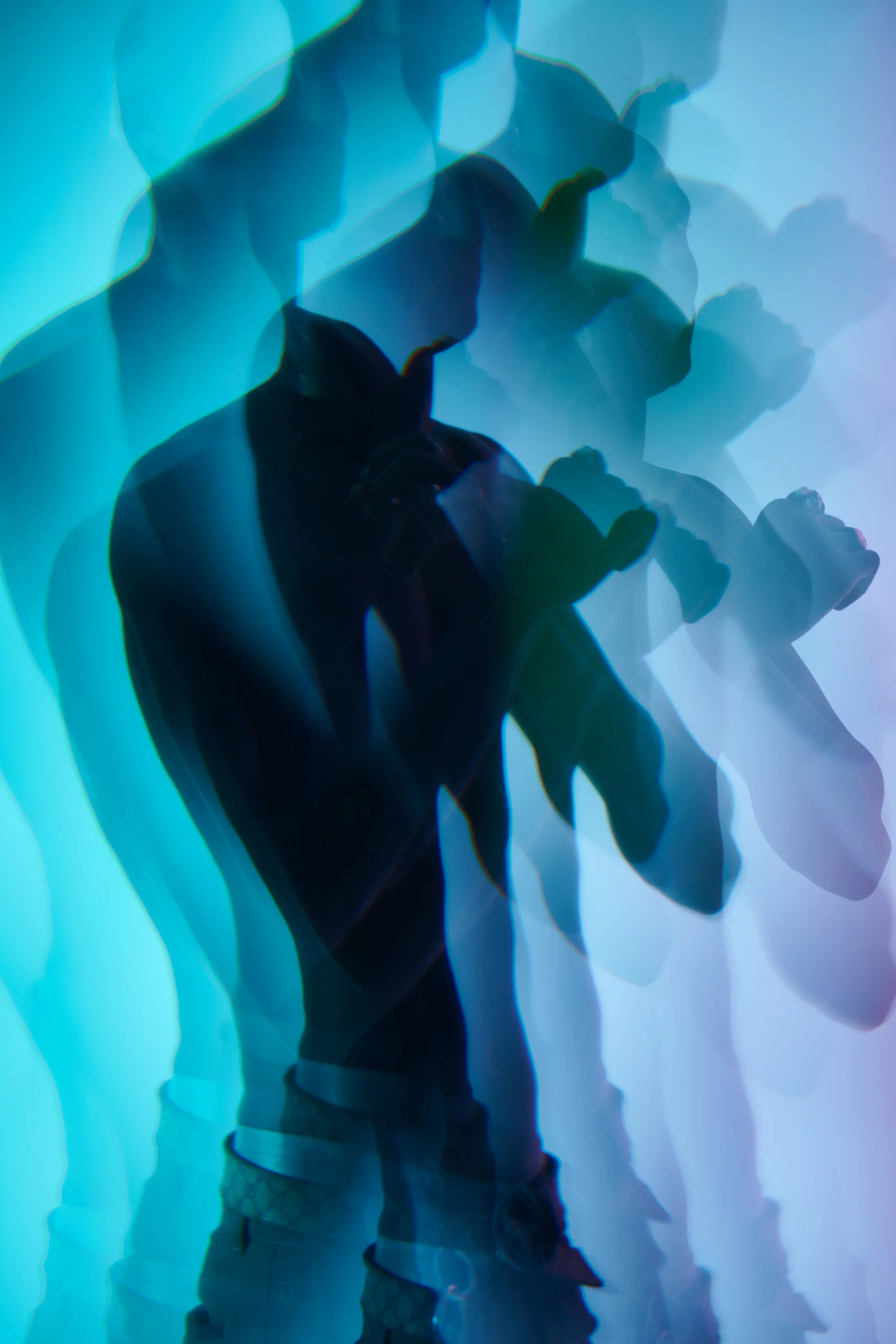 A figure with raised hands repeated in angular blue and cyan silhouettes.