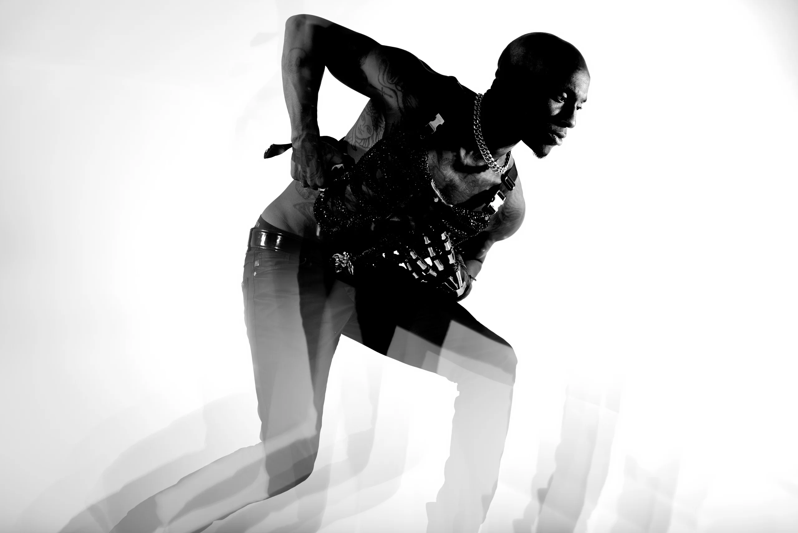 A black-and-white figure leaning forward, with repeated motion silhouettes around the legs.