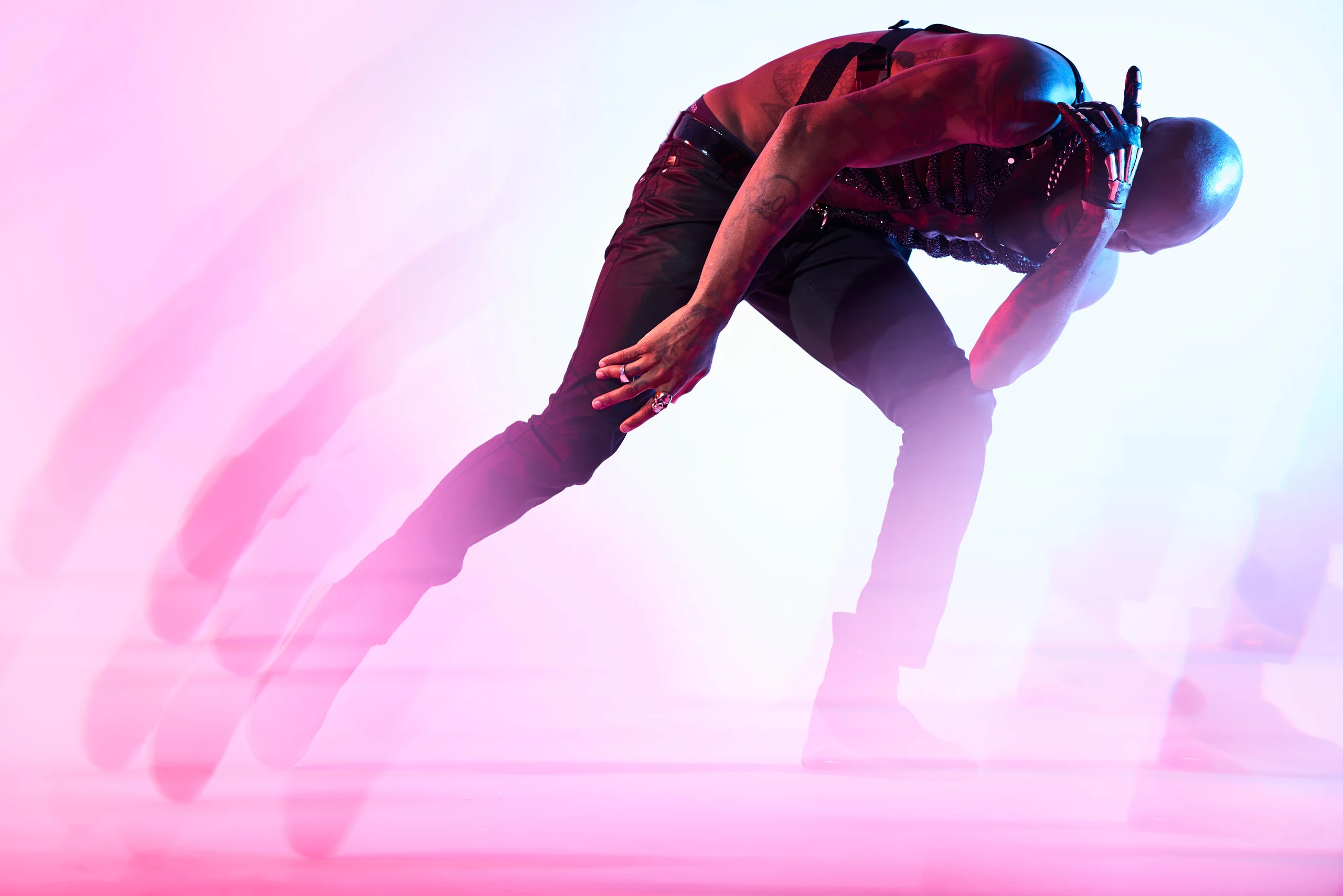 A bent figure reaching toward one knee, surrounded by pale repeated silhouettes.