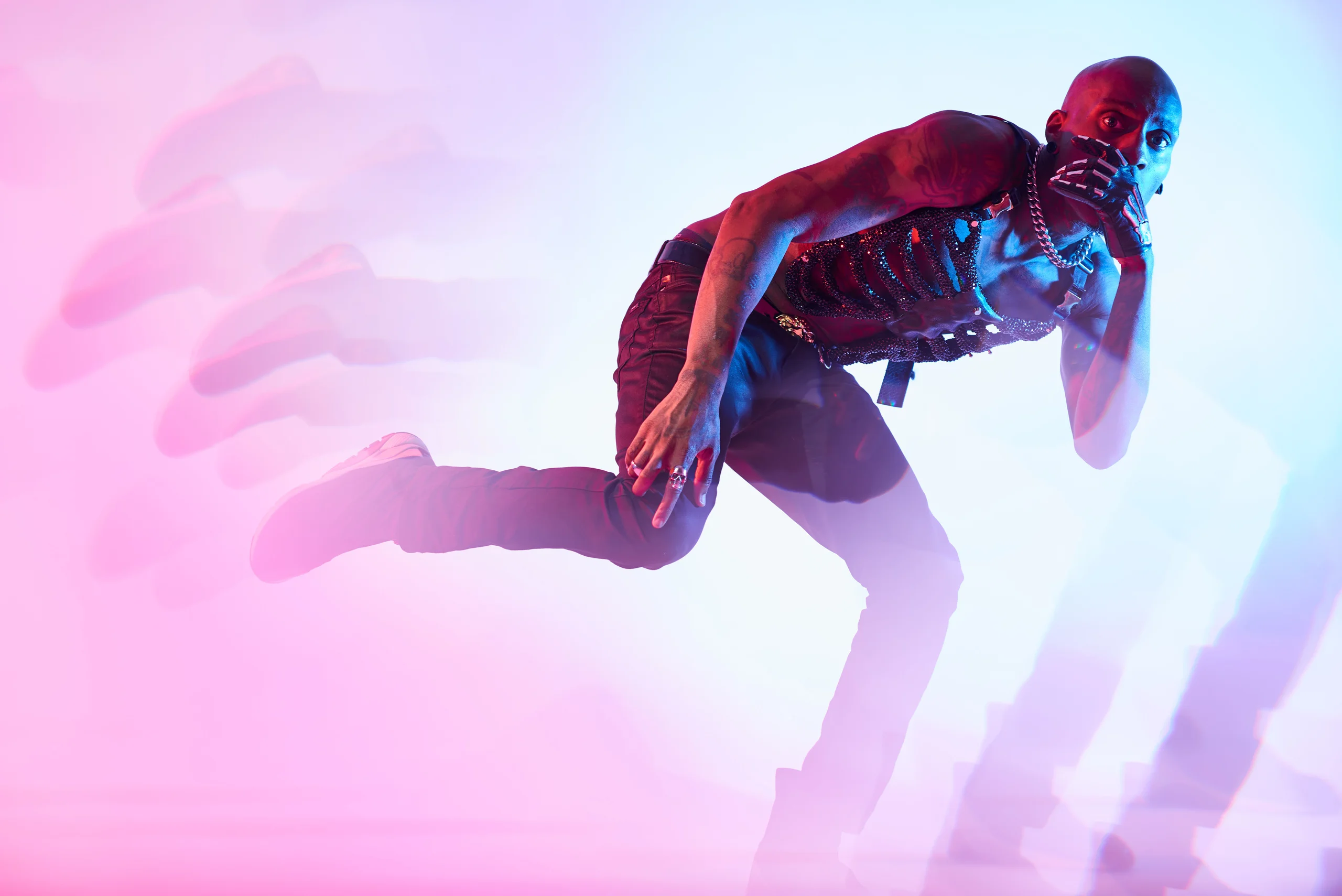 A figure leaning forward with one leg lifted behind and multiple pink motion trails.