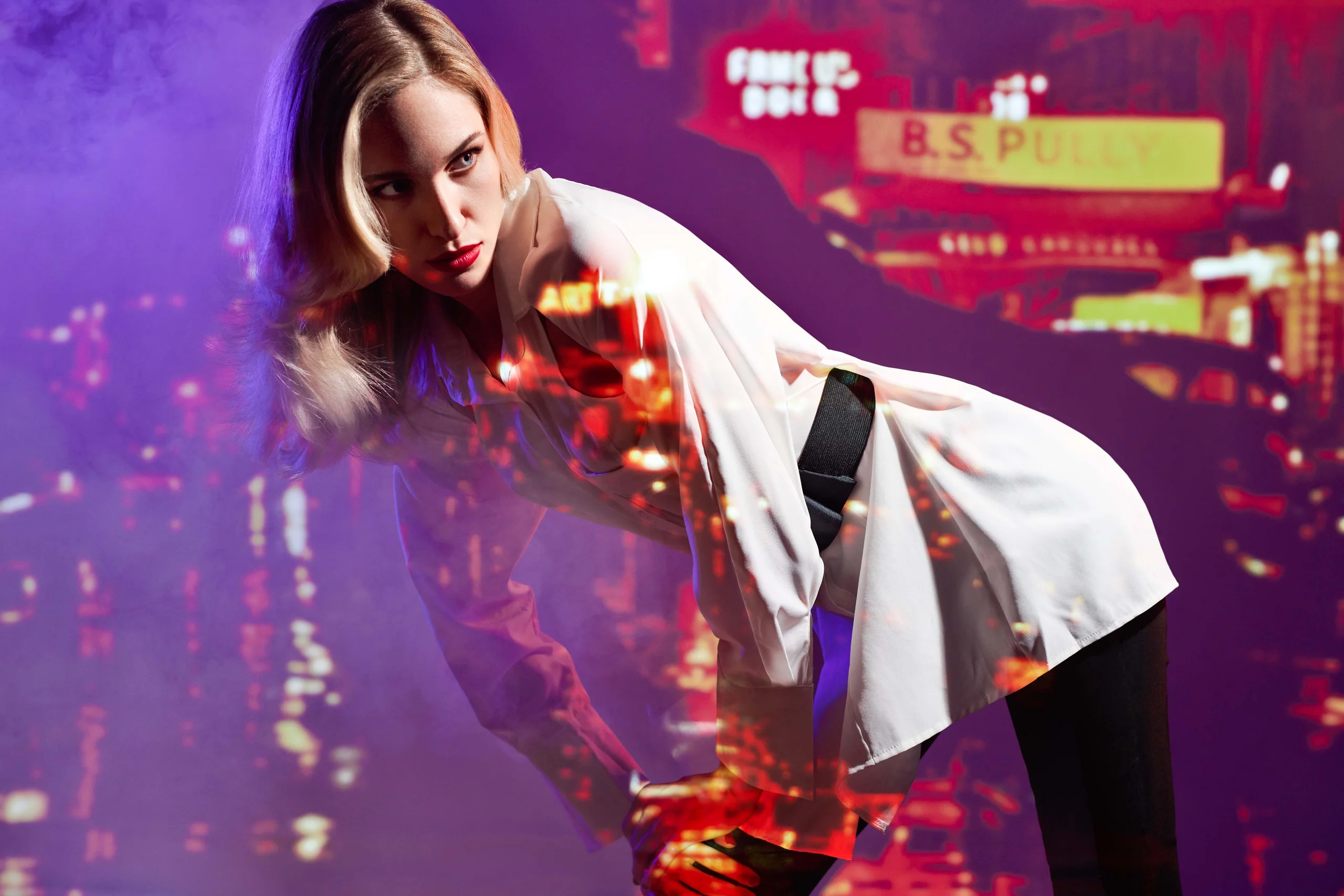 A model in a pale outfit with a colorful night-street scene projected across the image.