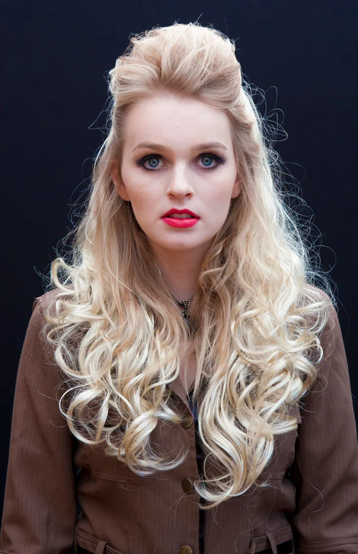 The source portrait of a blonde model wearing a dark jacket.