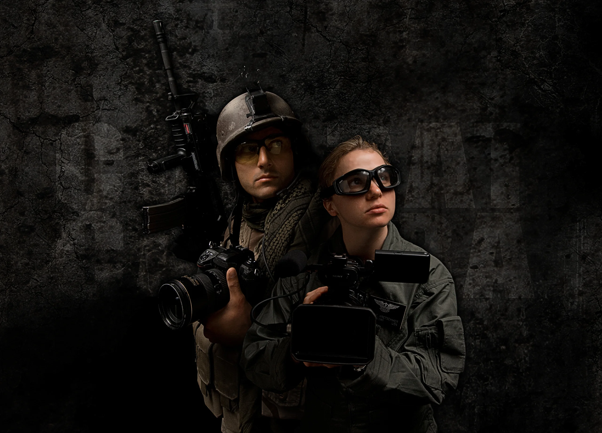 Two people in protective vests, one wearing a helmet and the other sunglasses, against a dark backdrop.