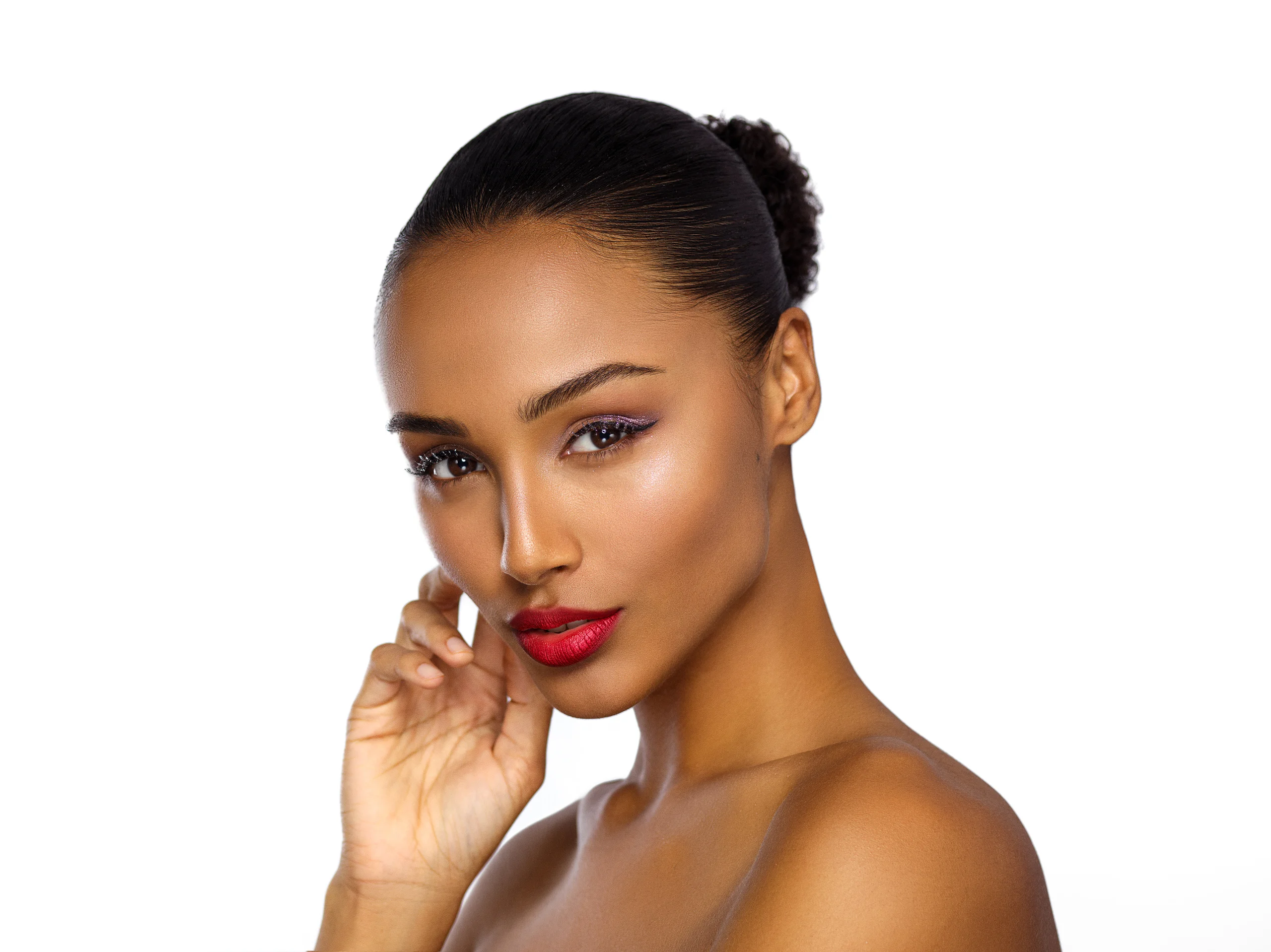 A beauty portrait with bright red lips and a hand near the face against white.