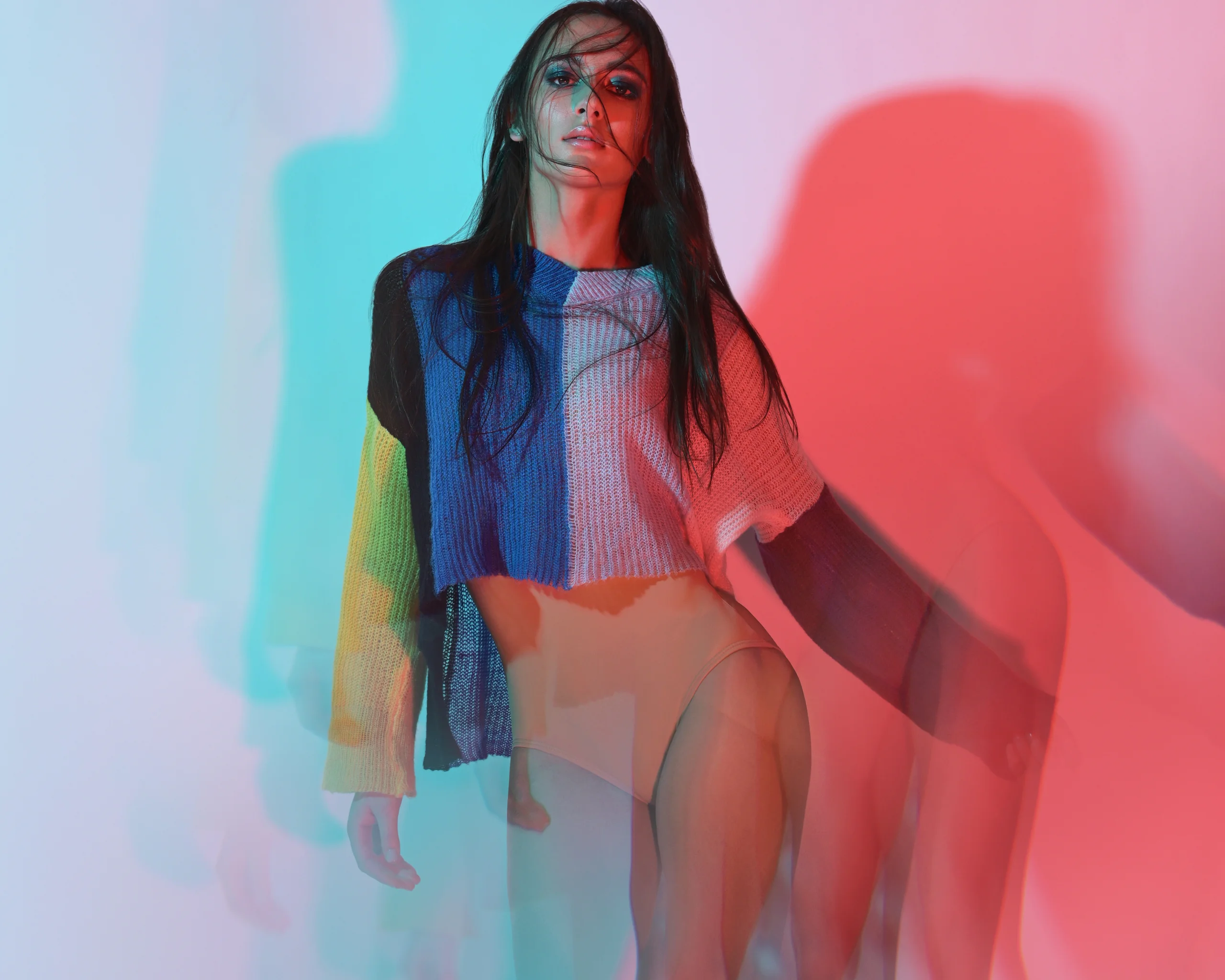 A fashion portrait with overlapping red and turquoise silhouettes.