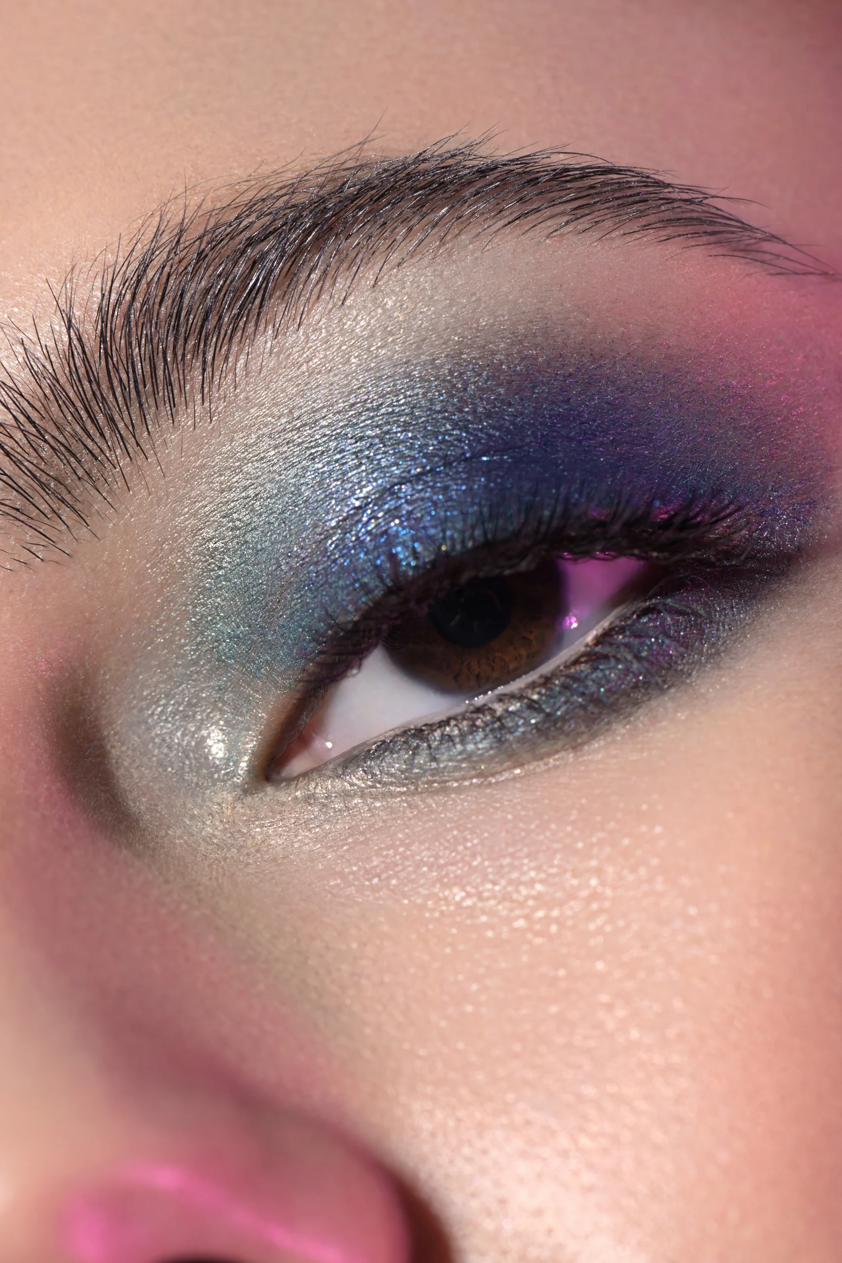 A close-up of shimmering blue and purple eye makeup.